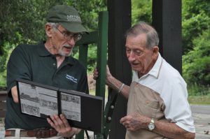 Rod Ham presents photo display of baggage cart to Hank Moffitt. Photo by Eric Baker 